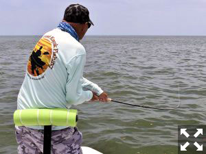 Steve Gibson, of Southern Drawl Kayak Fishing, battles a tarpon on fly tackle in the coastal gulf while fishing with Capt. Rick Grassett.