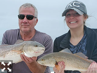 Mark Templeton and Ashley with a couple nice redfish they caught this past week.