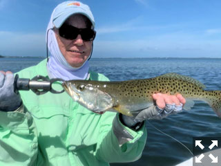 Ray Hutchinson, from MI, with a nice trout caught and released on a Clouser fly while fishing Sarasota Bay with Capt. Rick Grassett recently.