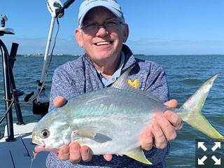 Ray Hutchinson, from MI, with a pompano caught on a fly while fishing deep grass flats of Sarasota Bay in a previous December with Capt. Rick Grassett.
