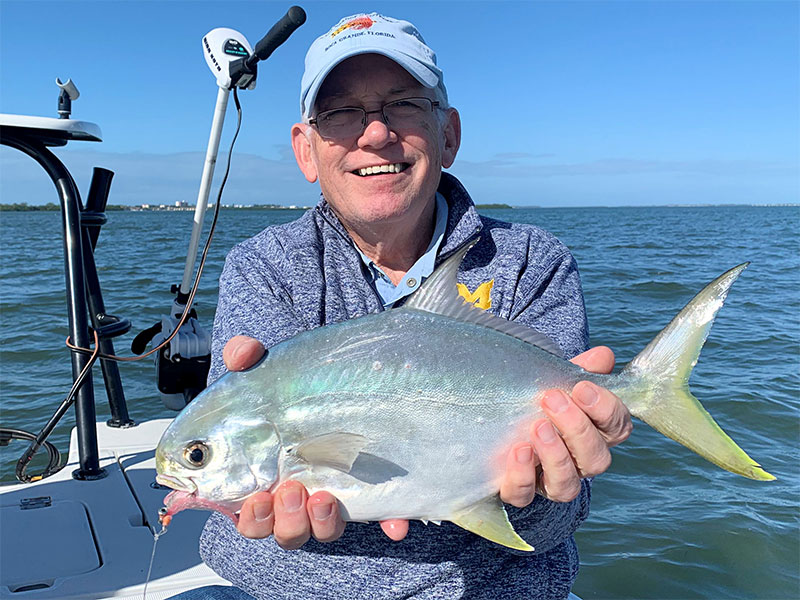 Ray Hutchinson, from MI, with a pompano caught on a fly while fishing deep grass flats of Sarasota Bay in a previous December with Capt. Rick Grassett.