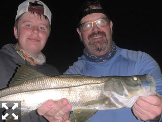 Mark and Trenton Moreni, with a snook caught and released on a fly while fishing Sarasota Bay at night with Capt. Rick Grassett.