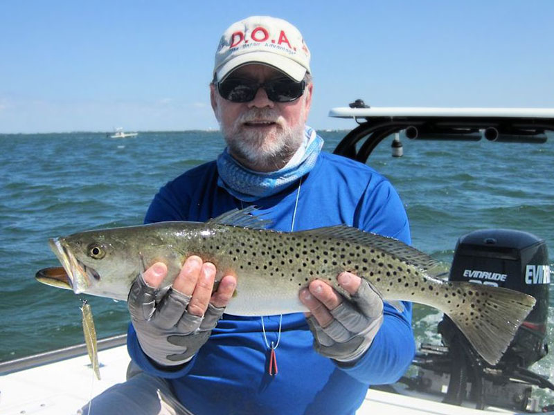 Capt. Rick Grassett with a 24" trout, both caught and released on DOA Lures in a previous April.
