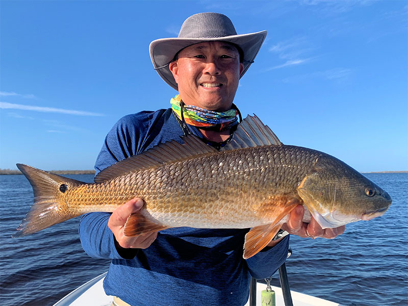 Jon Yenari, from Sarasota, with a red he caught and released on fly and CAL jigs with shad tails while fishing Gasparilla Sound near Boca Grande with Capt. Rick Grassett recently.