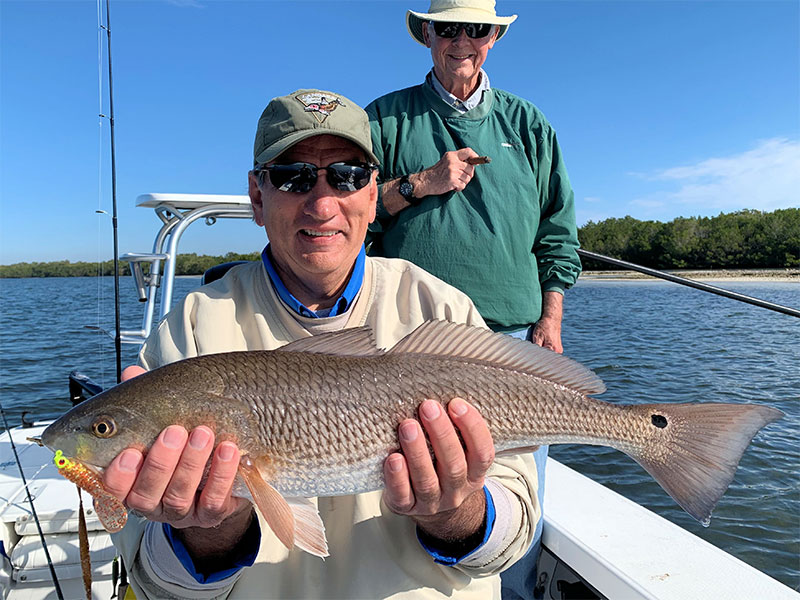 Eric Mueller, from IL, with a red caught and released on CAL jigs with shad tails while fishing Gasparilla Sound with Capt. Rick Grassett in a previous February.