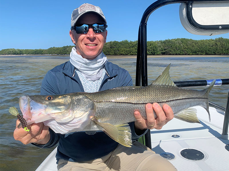 Dave Reinhart, from MA, with a snook he caught and released on CAL jigs with shad tails while fishing Gasparilla Sound with Capt. Rick Grassett in a previous March. 
