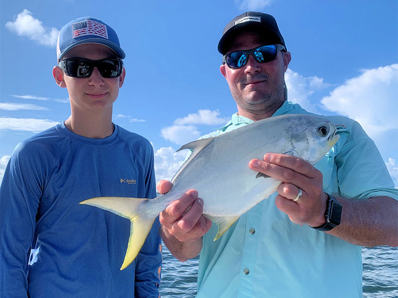 Connor Pullum and his dad Steve with a pompano they caught and released on DOA Lures while fishing Sarasota Bay with Capt. Rick Grassett.