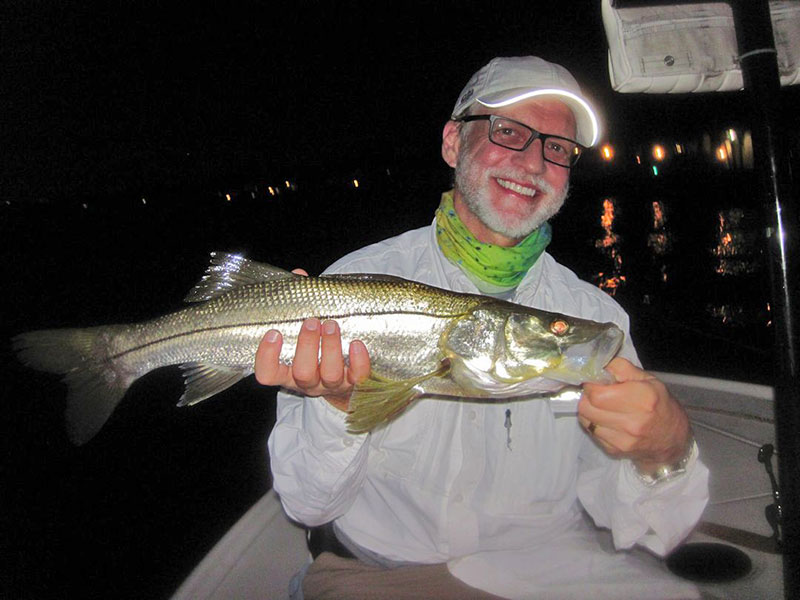 Beat the heat by fishing in the dark in August and then fish shallow flats early n the day. Dan Stults, from IL, with a snook caught on a fly while fishing with Capt. Rick Grassett in a previous August.